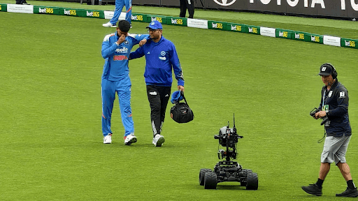 Shreyas Iyer, joueur de cricket indien, aidé par un membre du staff médical sur le terrain, illustrant les moments spectaculaires du cricket mentionnés dans l'article sur Alex Carey.