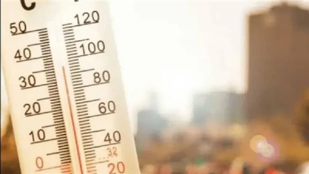 Thermomètre indiquant une chaleur accablante en Égypte avec un fond urbain brumeux.