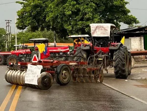 Tractores de agricultores colombianos bloquean una carretera durante el paro arrocero.