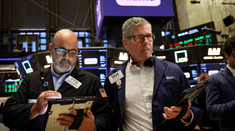 Traders monitoreando pantallas en un mercado financiero, simbolizando la volatilidad económica.