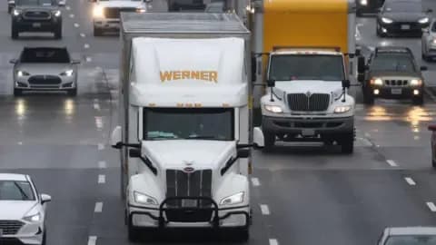 Trucks and cars on a highway, representing supply chains and infrastructure impacted by weather, requiring strategic forecasting and preparedness.
