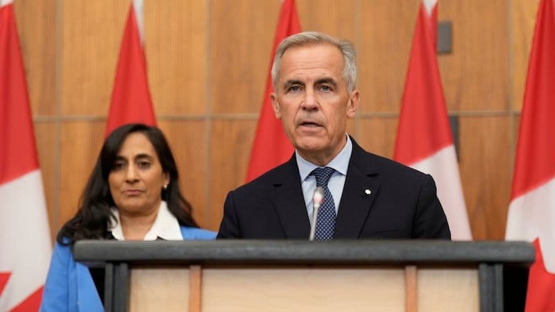 Two Canadian government officials, a man and a woman, standing at a podium with Canadian flags behind them, representing policy announcements and proposed reforms.