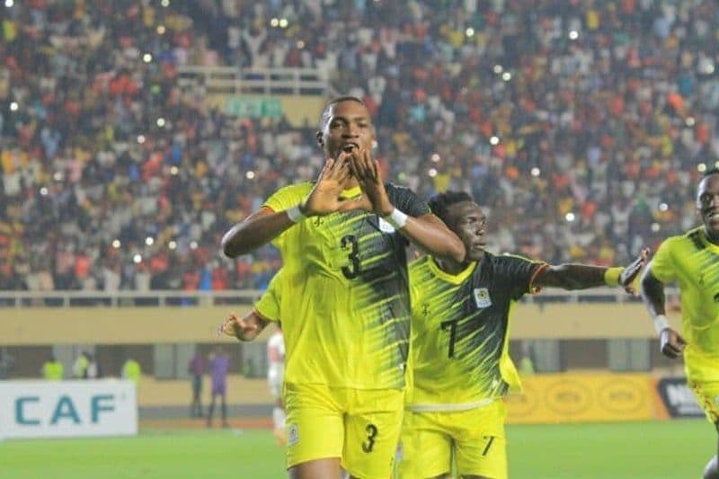 Ugandan football players celebrating a goal in a packed stadium, showcasing the home crowd's energy.