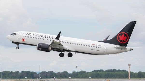 Un avion d'Air Canada au décollage, illustrant l'impact des incertitudes commerciales sur l'industrie du voyage.