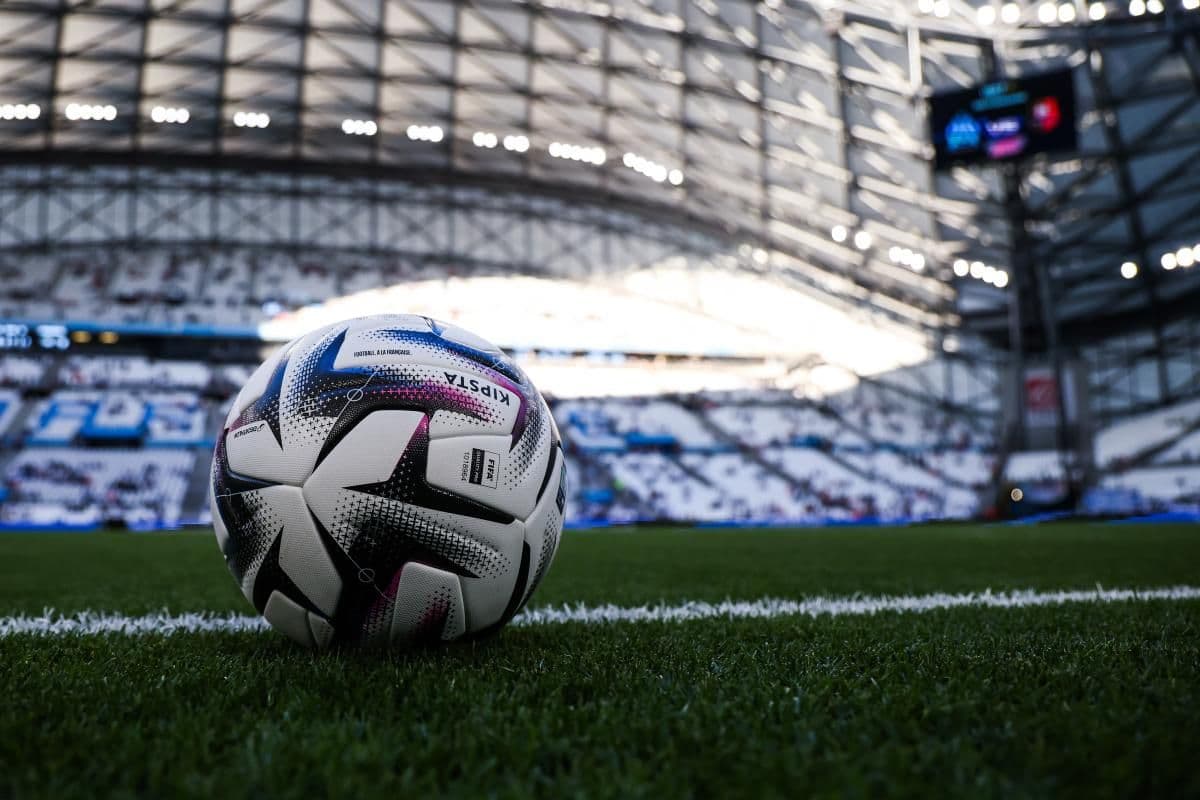 Un ballon officiel de la Ligue 1 sur le terrain, symbolisant le marché français du football agité par l'offre colossale pour Franculino Dju.