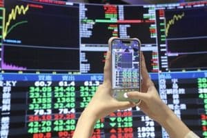Un écran boursier affichant des données financières, symbolisant l'incertitude des marchés face aux menaces tarifaires.