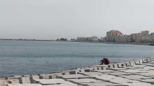 Un homme au bord de la mer en Égypte, représentant les conditions maritimes et côtières.