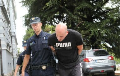 Un homme menotté escorté par la police, symbolisant le début des poursuites judiciaires dans l'affaire Agrokor.