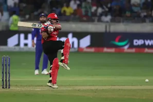 Un joueur de cricket de Hong Kong en pleine action de batteur, représentant la détermination des nations associées.