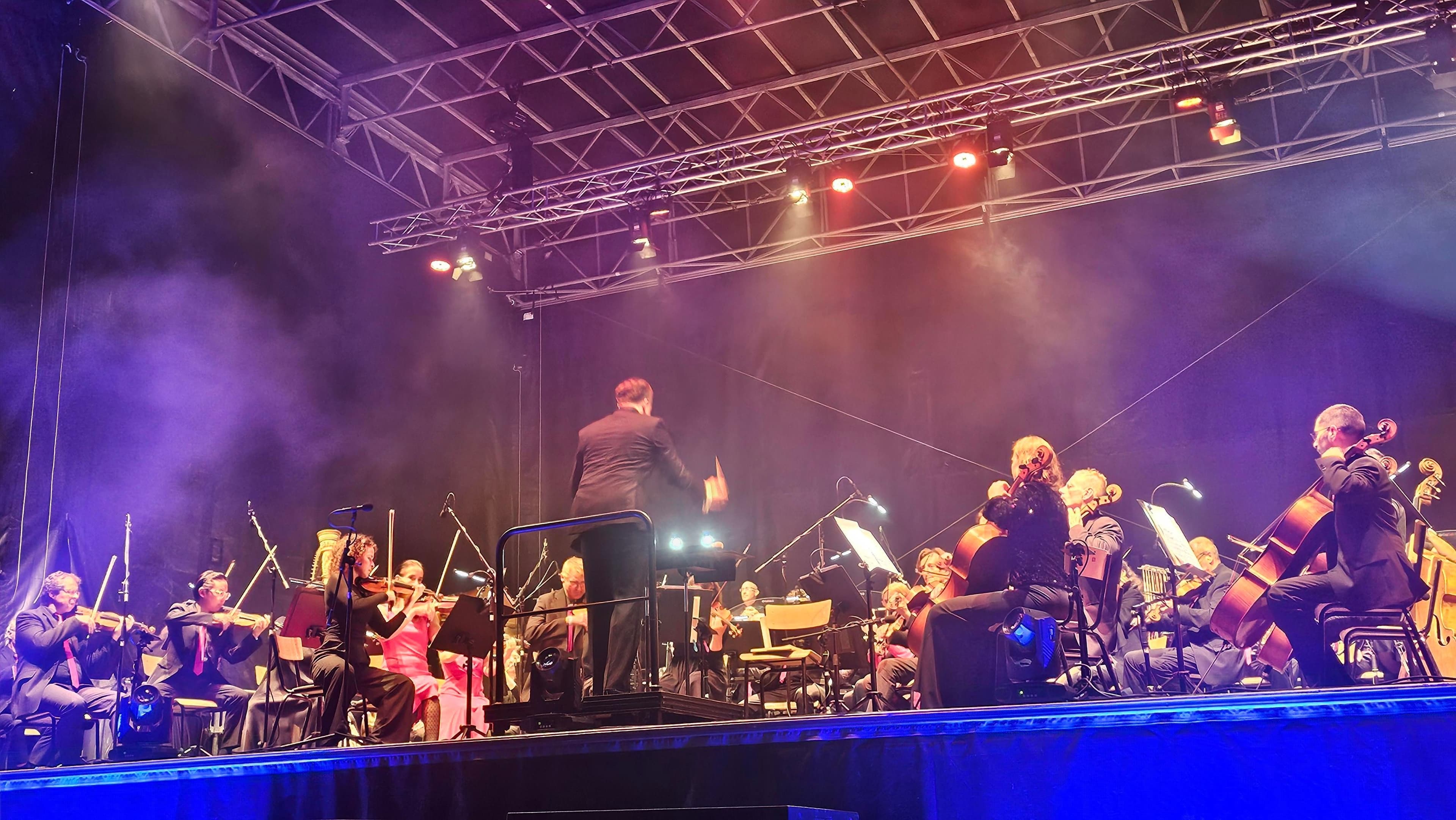 Un orchestre jouant sur scène, représentant les événements publics potentiellement interrompus par les orages.