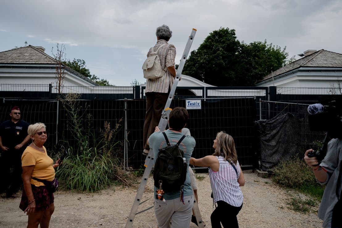 Un policier surveillant les manifestants près de la clôture du domaine de Hatvanpuszta.