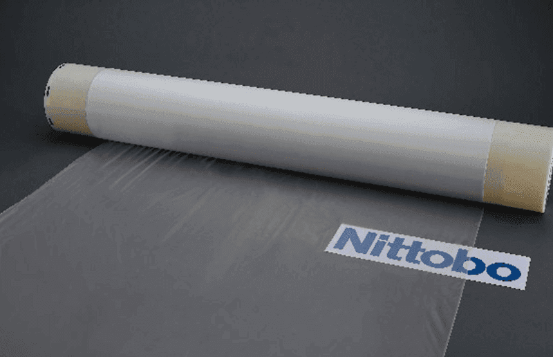 Un rouleau de tissu de fibre de verre T-Glass de Nitto Boseki, le matériau essentiel pour les serveurs IA et les PCB, symbolisant son rôle clé dans la révolution technologique et son impact boursier.