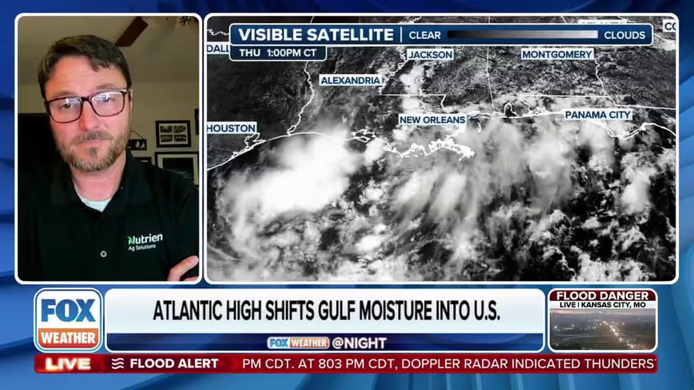 Un scientifique météorologique analysant une carte satellite montrant l'humidité du Golfe et les systèmes nuageux au-dessus du sud-est des États-Unis.