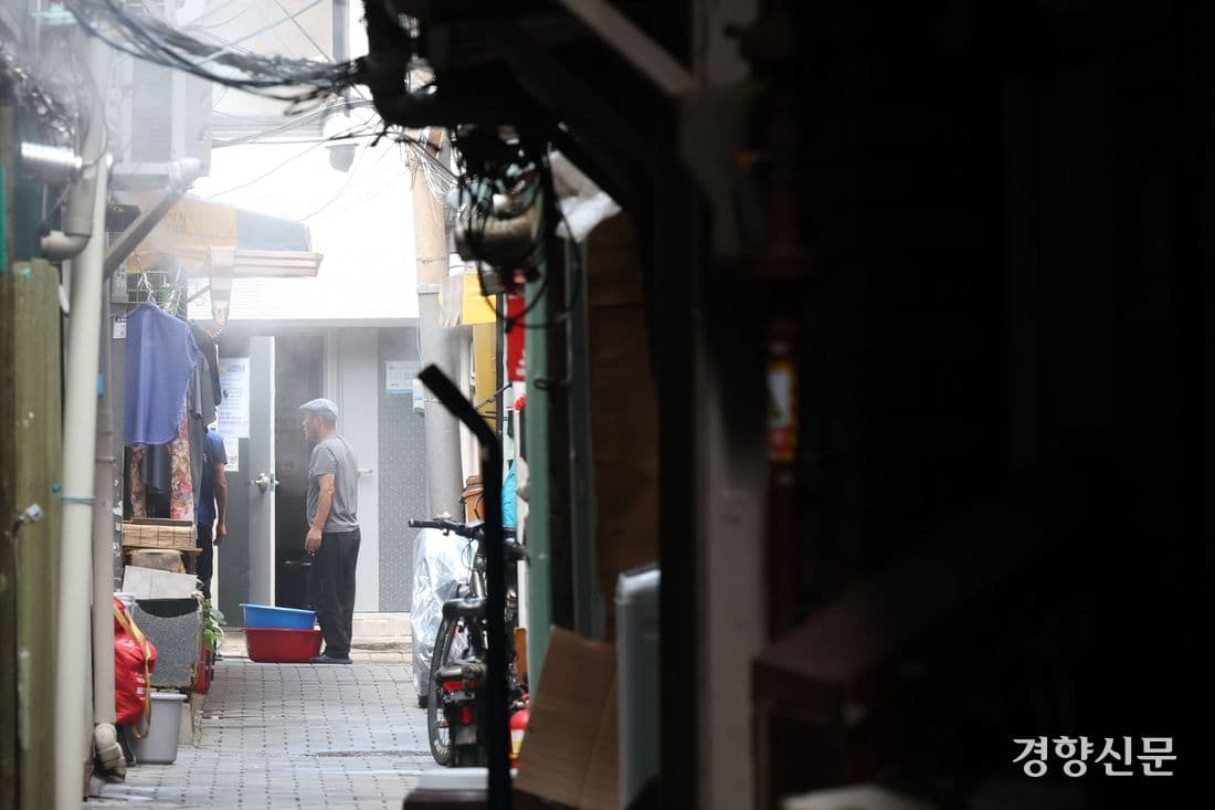 Un système de brumisation (cooling fog) en fonctionnement dans une ruelle étroite d'un quartier précaire (jokbangchon) pour lutter contre la chaleur.