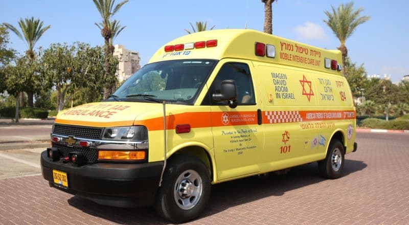 Une ambulance jaune garée sous un ciel ensoleillé, symbolisant les risques pour la santé liés à la canicule.