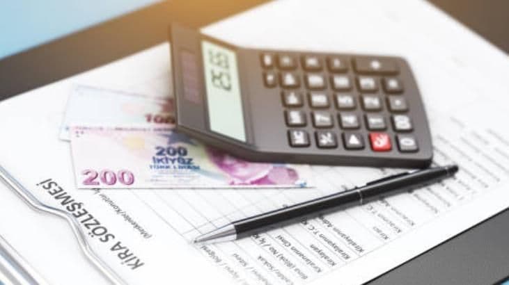 Une calculatrice, des billets de lire turque et un contrat de location, illustrant le calcul des nouveaux taux de loyer.