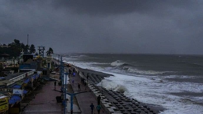 Une côte balayée par une tempête violente avec de grandes vagues et un ciel sombre, représentant l'impact des phénomènes météorologiques extrêmes.