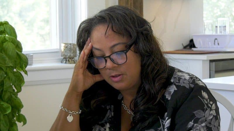 Une femme avec la main sur la tête, représentant la vulnérabilité et l'anxiété des travailleurs migrants.