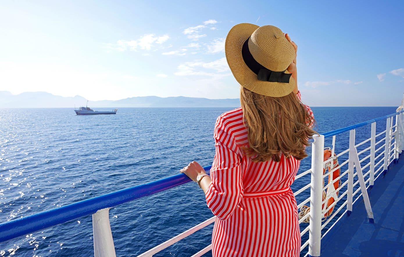 Une femme en vacances sur un ferry, symbolisant les risques d'intoxication alimentaire même en voyage.