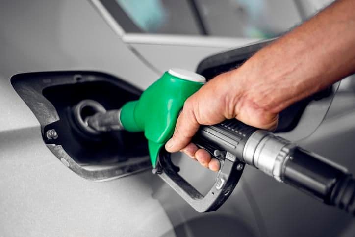 Une main remplissant un réservoir de voiture à la pompe, symbolisant les fluctuations des prix du carburant en Turquie.