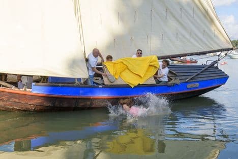 Une personnalité est jetée d'un bateau dans l'eau, créant une grande éclaboussure lors de la tradition annuelle de l'Unikeko à Naantali.