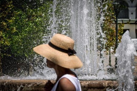 Une personne portant un chapeau de paille pour se protéger du soleil, illustrant les stratégies individuelles face à la chaleur.