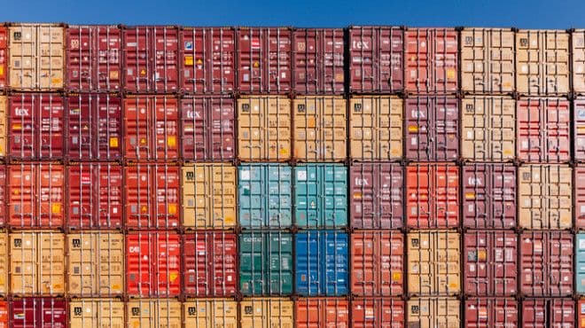 Une pile de conteneurs d'expédition colorés, symbolisant la nécessité pour la Suisse de repenser sa stratégie commerciale mondiale.