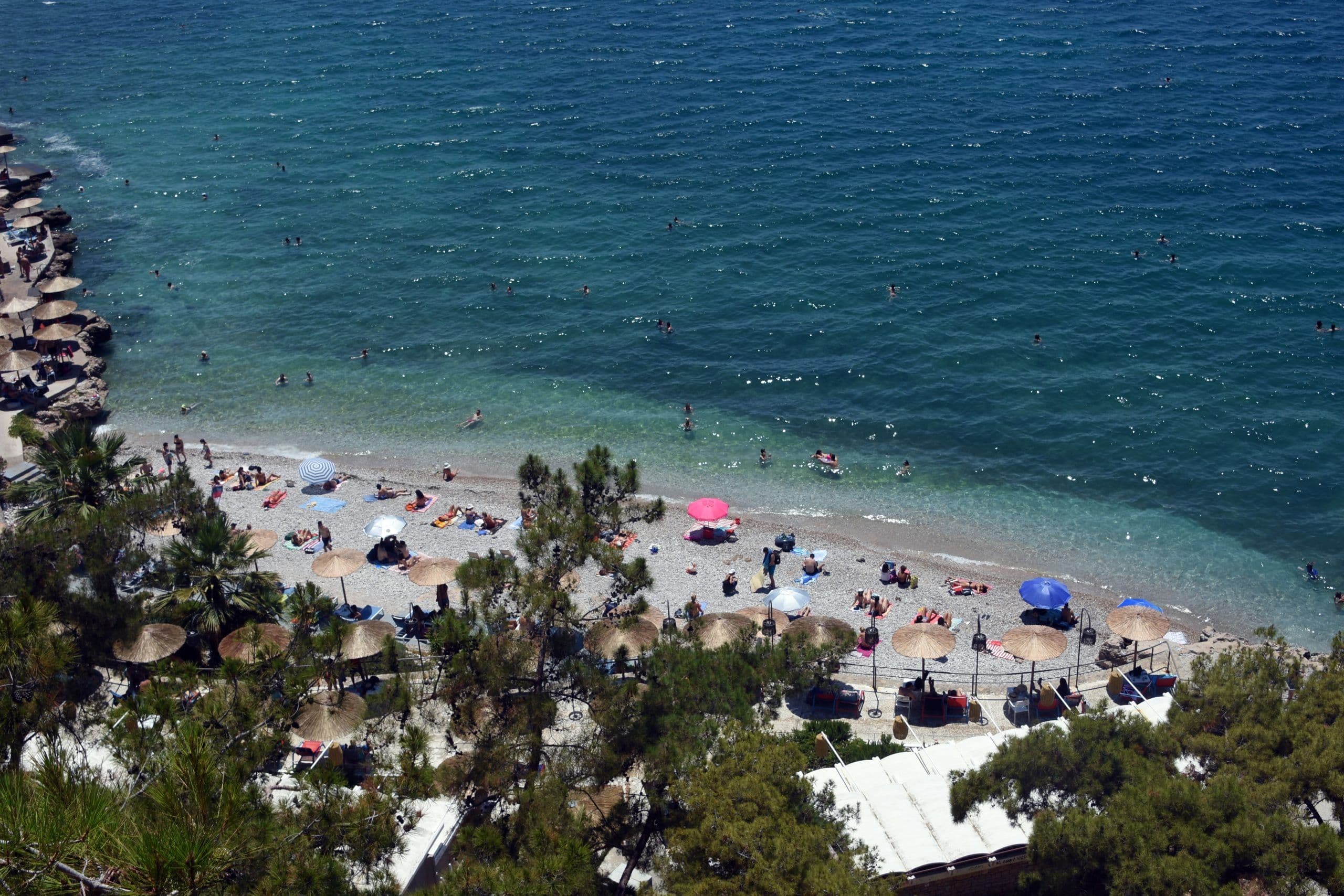 Une plage grecque sous un ciel changeant, symbolisant la transition de la canicule aux orages.
