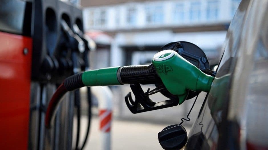 Une pompe à carburant verte insérée dans le réservoir d'une voiture, symbolisant la hausse du prix du diesel.