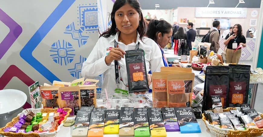 Une productrice péruvienne souriante présente des produits de café et de cacao issus du développement alternatif à Expoalimentaria 2025.