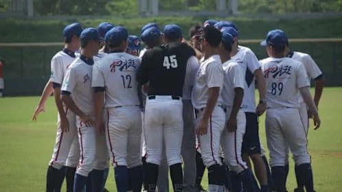 Une équipe de baseball en pleine discussion stratégique, symbolisant l'impact potentiel de Nama Hsia sur la dynamique de l'équipe et la saison.