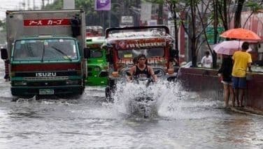 Une route inondée avec des véhicules, montrant les conséquences des tempêtes et typhons.