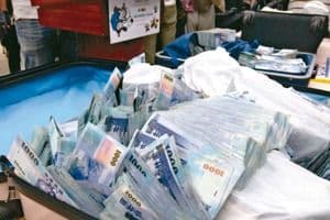 Une valise remplie de billets de dollars taïwanais, illustrant les donations mentionnées dans le procès.