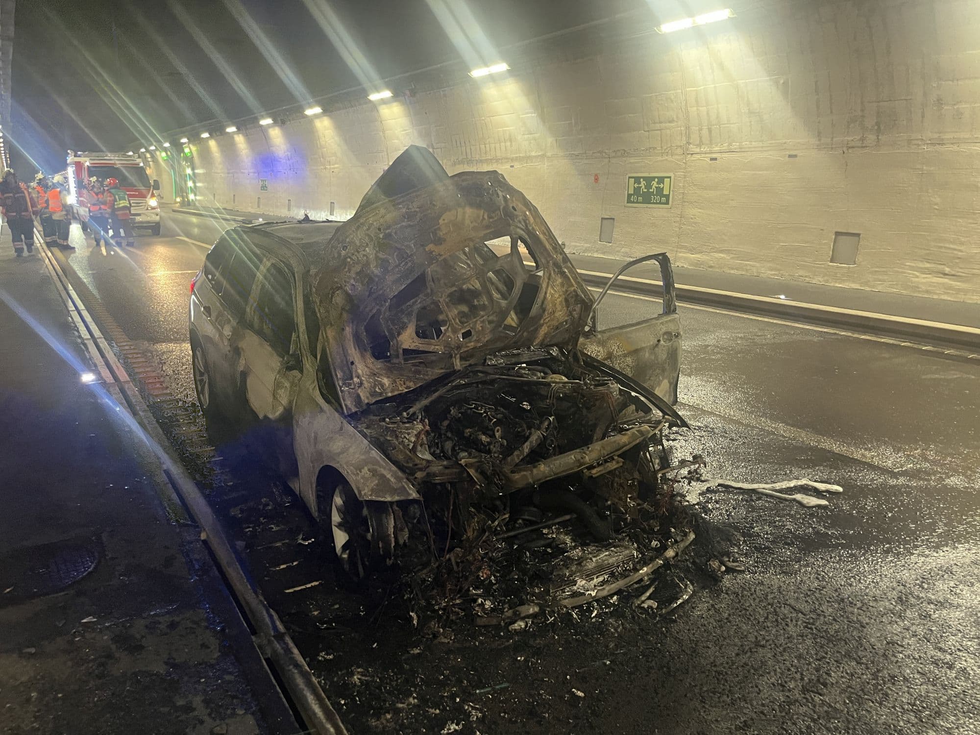 Véhicule incendié dans le Belchentunnel avec les services d'urgence, illustrant l'incident majeur.