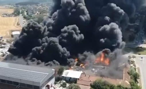 Vue aérienne d'un grand incendie avec une épaisse fumée noire au-dessus d'une zone habitée en Bulgarie.