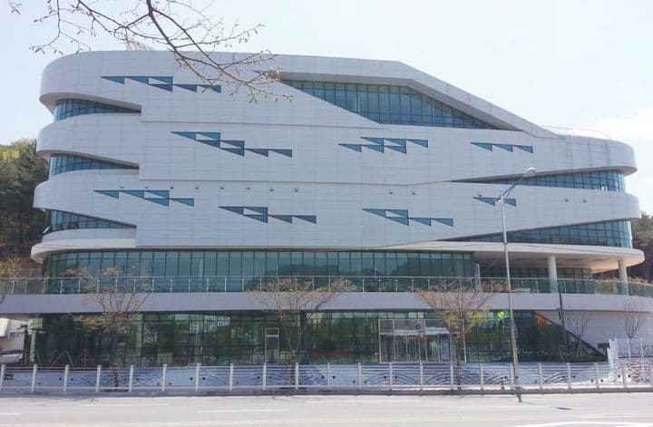 Vue extérieure d'un bâtiment moderne et imposant, symbolisant l'architecture et l'envergure de KINTEX.