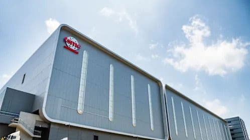 Vue extérieure d'une usine de semi-conducteurs moderne, symbolisant la chaîne d'approvisionnement des plaquettes de silicium et l'impact de la reprise du marché de la mémoire.