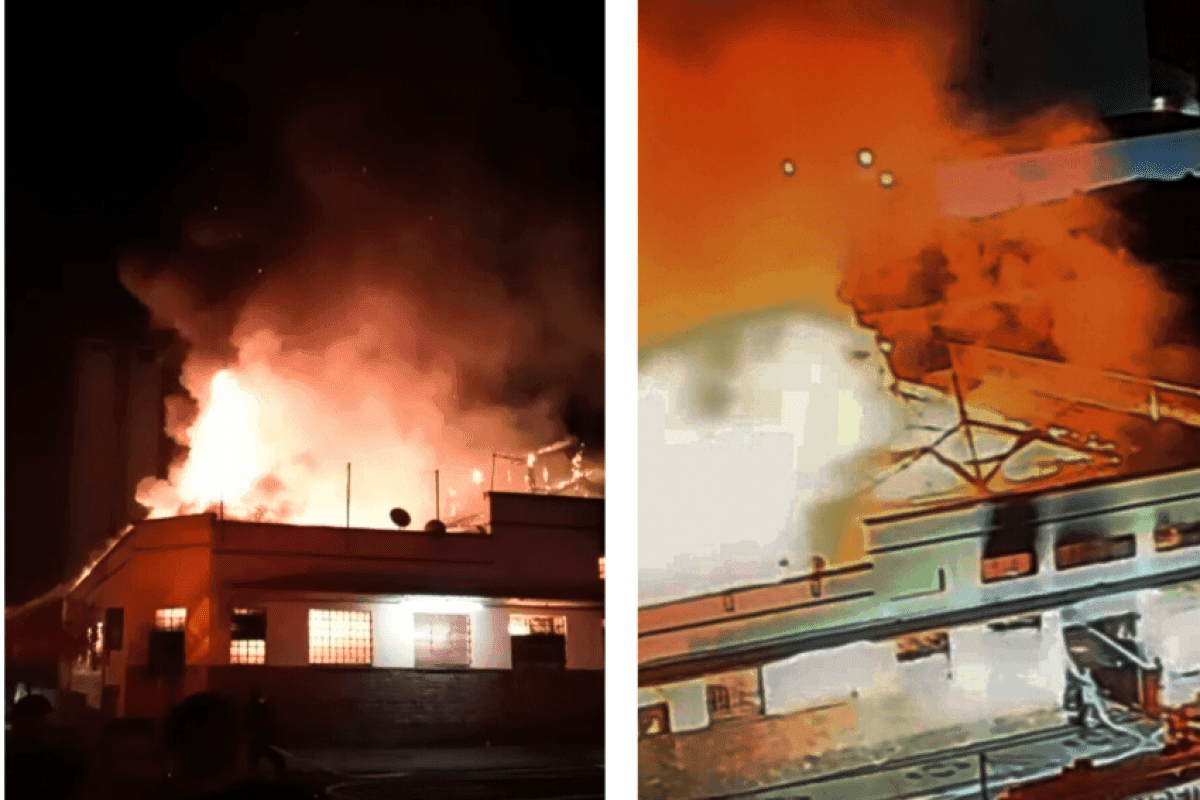 Vue nocturne du Mercado Municipal de Piracicaba en proie à un incendie dévastateur, avec d'immenses flammes et de la fumée s'élevant du bâtiment historique.
