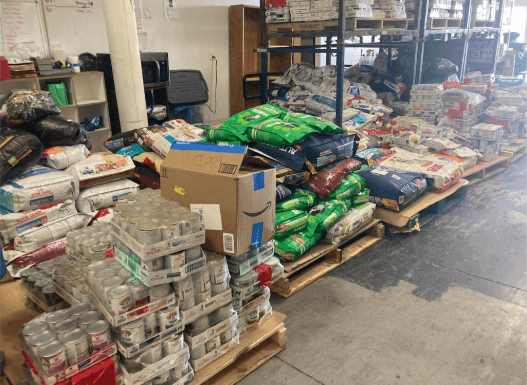 Warehouse filled with pet food and supplies, representing community support for animal rescues in changing environments