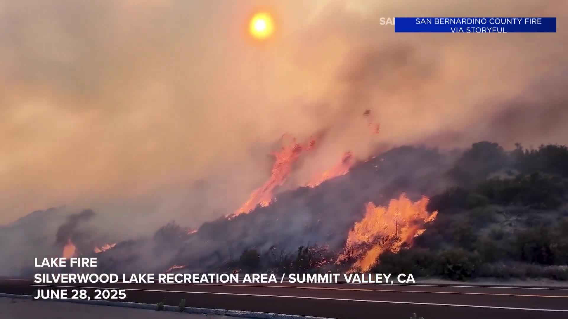 Wildfire raging up a hillside with smoke filling the sky, illustrating the profound impact of extreme weather events and the need for adaptation.