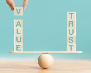 Wooden blocks balancing 'VALUE' and 'TRUST' on a seesaw, representing the Brent market's paradoxical state and strategic challenges
