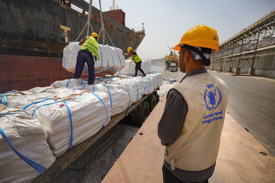 World Food Programme personnel overseeing the offloading of humanitarian food cargo at a port.