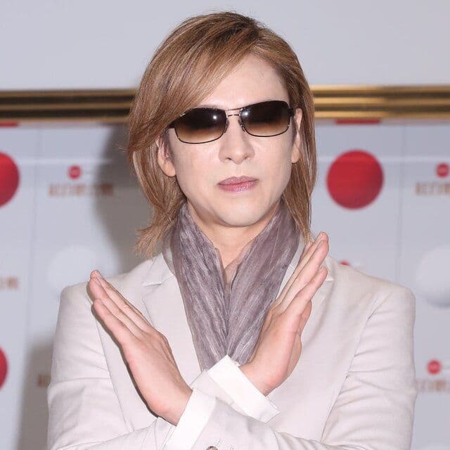 YOSHIKI from LUNA SEA, a popular figure in McDonald's Japan's 'LUNA CHEE' campaign, making an 'X' gesture.